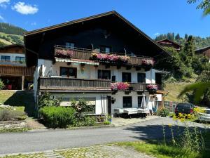 a house with flowers on the balconies on a street at Appartement Unterstein 1 in Niedernsill