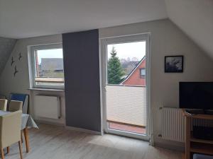 a living room with two windows and a television at FeWo Petersen, Köhn in KÃ¶hn