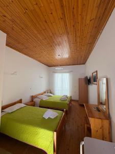a bedroom with two beds and a wooden ceiling at Elena Rooms in Agios Nikitas