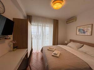 a bedroom with a bed with two towels on it at Apartments Ivančić in Novi Vinodolski
