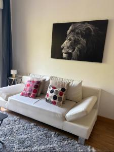 a white couch in a living room with a lion painting at La Rotonde in Aix-en-Provence