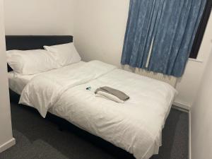 a bed with a white comforter and a towel on it at Ermihouse in Sheffield