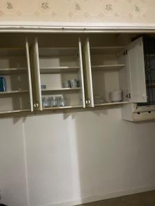 a kitchen cabinet with open doors with dishes in it at Ermihouse in Sheffield