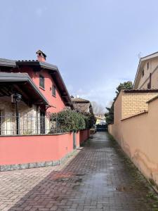 a cobblestone street next to a red building at Aura LT - Vicinissima all'aeroporto in Fiumicino