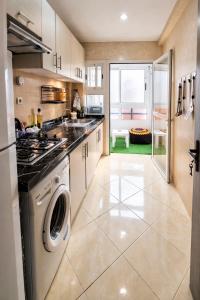 a large kitchen with a washer and dryer in it at Cozy appartement à Mohammedia in Mohammedia