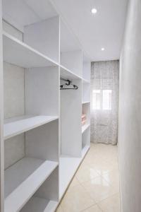 a white walk in closet with white shelves at Cozy appartement à Mohammedia in Mohammedia +3 photos