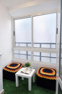 a room with two beds and a table and a window at Cozy appartement à Mohammedia in Mohammedia