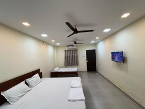 ein Schlafzimmer mit zwei Betten und einem Deckenventilator in der Unterkunft Aathidya Lodge in Ādoni