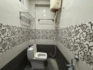 ein Badezimmer mit Toilette und schwarz-weißen Fliesen in der Unterkunft Aathidya Lodge in Ādoni + 2 Fotos