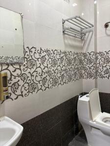 ein Badezimmer mit Toilette, Waschbecken und Spiegel in der Unterkunft Aathidya Lodge in Ādoni