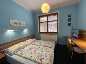 a bedroom with a bed and a desk and a window at Penzion Andrej in Ružomberok +20 photos