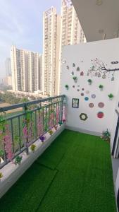 a balcony with green grass and a wall with plants at NXone STUDIO APARTMENT in Noida