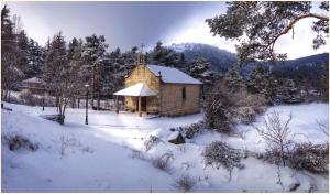 una pequeña iglesia en un campo cubierto de nieve en Hotel Lucía, en San Rafael