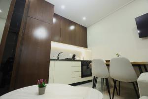 a kitchen with a white table and white chairs at The Swan Nest 2 in Pogradec +8 photos