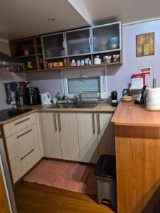 a small kitchen with white cabinets and a sink at Casa da praia fluvial o Moinho in Benquerença