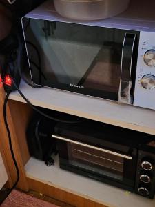 a microwave sitting on top of a shelf at Casa da praia fluvial o Moinho in Benquerença +9 photos
