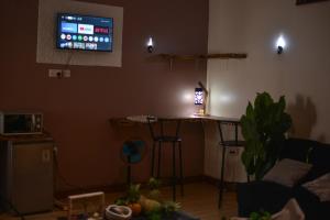 a living room with a table and a tv on the wall at Peryn Suites Kinubi, Hoima City, Uganda in Hoima