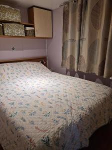a bed in a small room with a bedspread at Casa da praia fluvial o Moinho in Benquerença