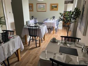 a restaurant with tables and chairs with white tablecloths at Castlecroft Bed and Breakfast in Stirling +37 photos