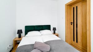 a bedroom with a large bed with a green headboard at Apartament Komfort Lux in Karpacz