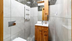 a white bathroom with a sink and a toilet at Apartament Komfort Lux in Karpacz