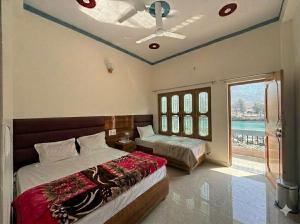 a bedroom with two beds and a window at Skyline Hotel in Uttarkāshi