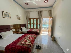 a hotel room with two beds and a window at Skyline Hotel in Uttarkāshi