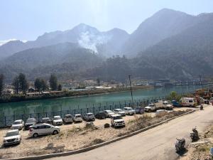 a bunch of cars parked in a parking lot next to a river at Skyline Hotel in Uttarkāshi