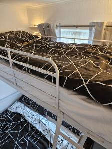 a bed with a brown comforter on top of it at 116 cherry park in Chapel Saint Leonards