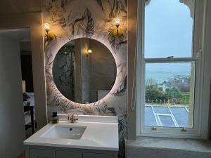 a bathroom with a sink and a mirror at Oakhurst Guesthouse in Cobh