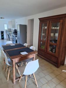a kitchen with a wooden table and white chairs at Maison Rustrel clim 3 chambres entre ocres et lavandes in Rustrel +14 photos