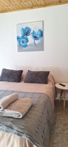 a bedroom with a bed and a painting on the wall at La casita in Zapala