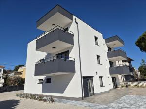 a white building with balconies on the side of it at Apartments Natalija1 -Krk in Krk
