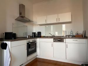 a kitchen with white cabinets and a sink and a stove at apartment37 in Detmold