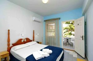 a bedroom with a bed with towels on it at Dolphin Hotel in Skopelos Town