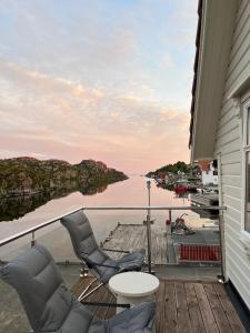 a balcony with chairs and a view of a river at Hus ved sjøen på Bømlo in Bømlo