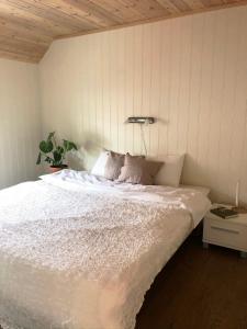 a bedroom with a large bed with white sheets at Hus ved sjøen på Bømlo in Bømlo