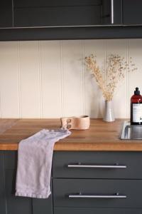a kitchen counter with a towel and a vase with flowers at Hus ved sjøen på Bømlo in Bømlo +11 photos