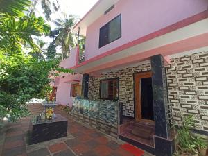a house with a courtyard in front of it at MAHASATHI HOMESTAY Murdeshwar in Māvalli