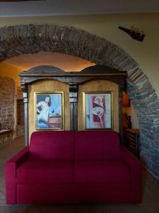 a purple couch in a living room with a brick wall at Rabat Home Luxury in Tursi