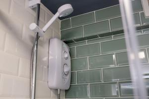 a shower in a bathroom with green tiles at Stylish Studio with Parking in Doncaster in Doncaster