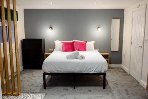 a bedroom with a large bed with pink pillows at Stylish Studio with Parking in Doncaster in Doncaster