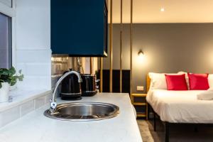 a kitchen with a sink next to a bed at Stylish Studio with Parking in Doncaster in Doncaster