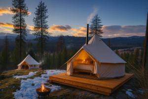 a luxury tent with a fire in the snow at Genesis Mountain Farm in Sandpoint