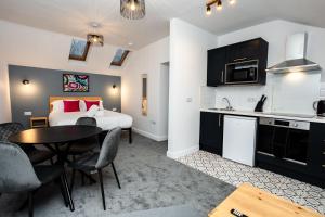 a room with a bed and a kitchen with a table at Loft-Style Studio with Skylights and Parking in Doncaster