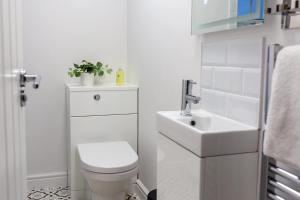 a white bathroom with a toilet and a sink at Loft-Style Studio with Skylights and Parking in Doncaster