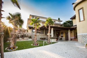 a house with palm trees in front of it at Villa Santa Caterina in Montalto Uffugo