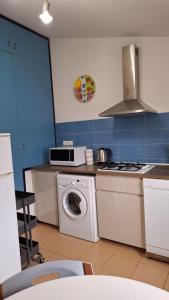 a kitchen with a washing machine and a microwave at A casa di Berta in Pietrasanta