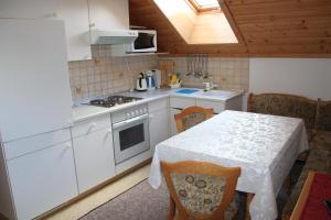 eine Küche mit einem Tisch und einer weißen Arbeitsplatte in der Unterkunft Schröckerhof in Mariapfarr