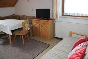 a living room with a table with a tv on it at Schröckerhof in Mariapfarr